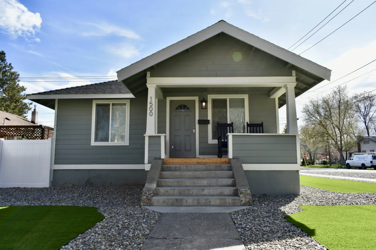 This image features a welcoming front porch and landscaped yard, perfect for enjoying the outdoors or sipping locally roasted coffee before a stroll downtown. The scene communicates both relaxation and immediate access to the vibrant neighborhood.